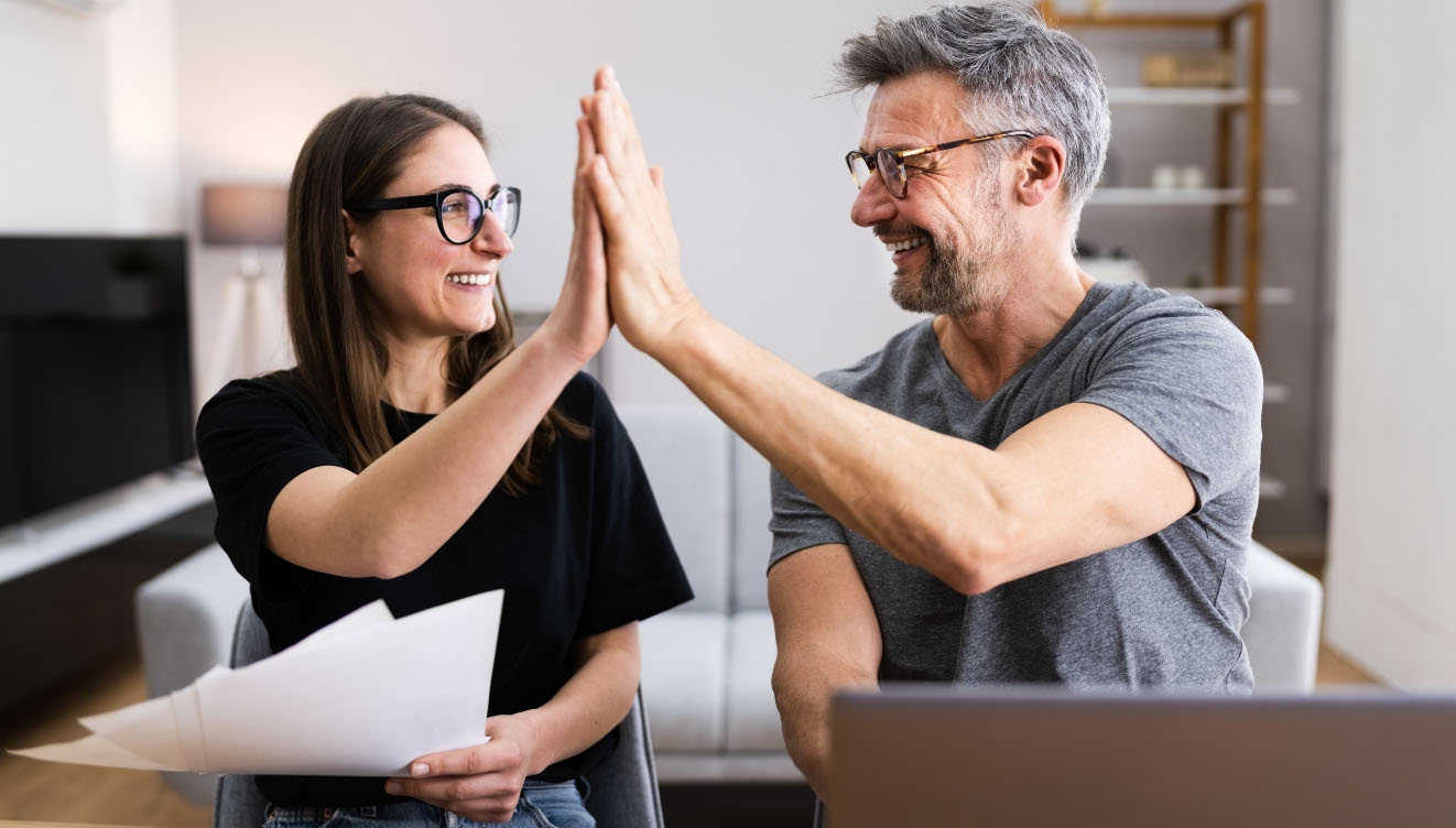 couple high-fiving after finishing taxes